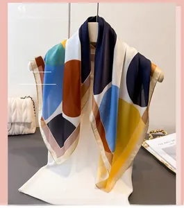 Detail of colorful geometric block print silk scarf draped on a mannequin with glossy texture