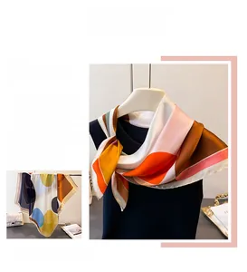 Detail of silk-like scarf featuring colorful geometric block patterns and elegant stitching