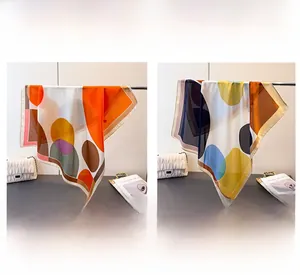 Detailed texture of colorful geometric dot print silk-like scarves in orange and khaki