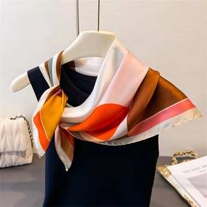 Elegant satin square scarf with colorful geometric prints tied on a black top