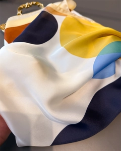 Macro detail of silk scarf with colorful geometric prints and vintage metal handle