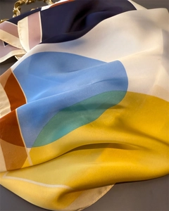Macro detail of silk-like square scarf featuring colorful geometric color block patterns