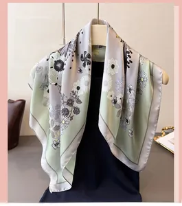Close-up of elegant silk scarf featuring detailed daisy patterns and grey border trim