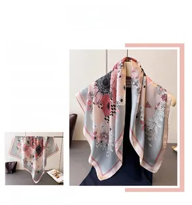 Detailed view of floral silk scarf featuring elegant daisy patterns in blue and pink tones
