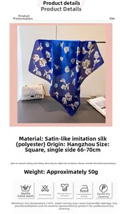 Détail d'un foulard carré en satin bleu marine avec imprimé de lys blancs et texture de soie douce