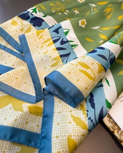 Macro detail of floral silk scarf featuring vibrant botanical patterns and satin texture