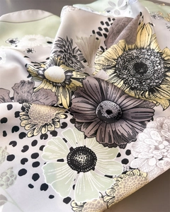 Close-up of elegant silk scarf with daisy floral print and polka dots fabric texture