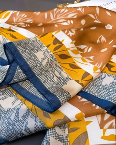 Detailed shot of silk-like floral scarf showing soft satin texture and geometric patterns