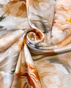 Vue macro d'un foulard en soie avec imprimé floral orange et texture satinée lisse