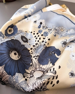 Detailed macro view of the silky daisy print fabric with elegant blue floral patterns
