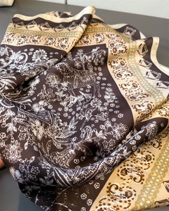 Detail of silk-like scarf featuring vintage horse and floral prints with paisley borders