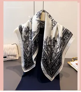 Detailed view of black and white floral print silk scarf with elegant satin finish