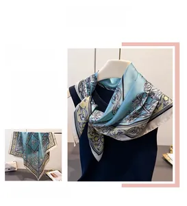 Detailed close-up of vintage floral pattern on blue silk-like square scarf fabric