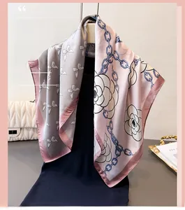Detail of silk-like square scarf featuring chain prints and camellia floral patterns