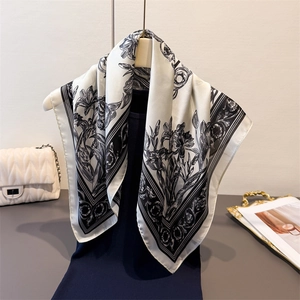 Elegant black and white floral faux silk square scarf displayed on a mannequin