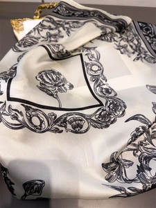 Detail of silk-like scarf featuring elegant black ink peony floral print on pearl white