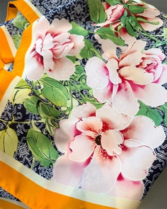 Dettaglio di sciarpa in seta con stampa floreale di peonia, nuvole e bordo arancione
