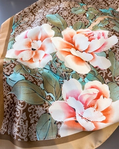Dettaglio della stampa floreale di peonia su sciarpa quadrata in finta seta con bordo dorato.