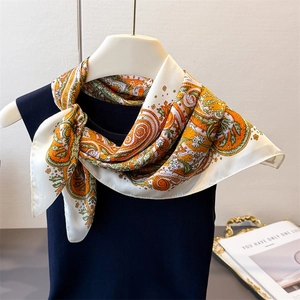 Elegant paisley print silk-like square scarf tied on a hanger for styling display