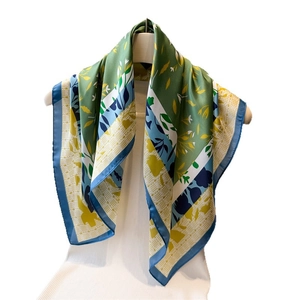 Elegant floral silk scarf featuring colorful botanical prints on a white mannequin