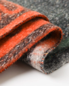 Close-up of soft thick cashmere-like fabric showing orange and brown knit texture