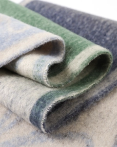 Macro detail showing thick cashmere-like texture and soft gradient stripes on scarf