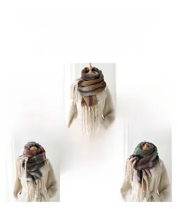 Detail of warm cashmere-feel scarf with rainbow plaid patterns and soft fringe tassels