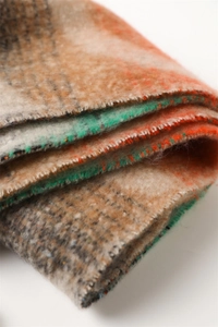 Close-up of thick rainbow plaid scarf with soft brushed texture and vibrant tassels