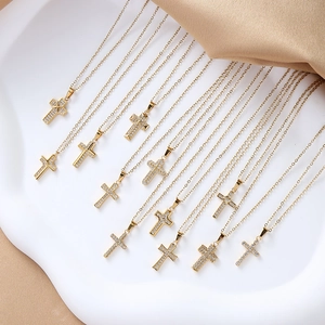 Macro shot of gold-plated cross necklaces with sparkling cubic zirconia on satin fabric