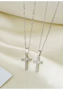 Detailed view of silver cross necklaces with zircon heart and pavé crystal settings