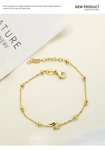 Close-up of gold clover bracelet with tiny zircon inlay and adjustable lobster clasp