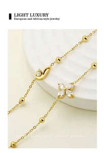 Macro detail of gold clover bracelet with sparkling cubic zirconia and engraved beads