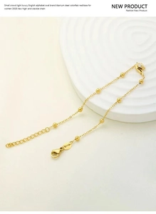 Detail of gold titanium steel beaded chain featuring a lobster clasp and extension links