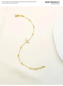 Detailed shot of gold titanium steel clover bracelet with cubic zirconia and beads