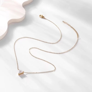 Macro detail of gold plated necklace with triangle cubic zirconia pendant and lobster clasp
