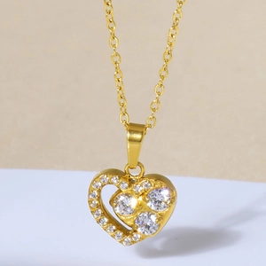 Dettaglio del ciondolo a cuore dorato con micro-pavé di zirconi su una catena sottile