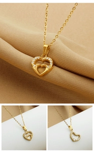 Dettaglio macro della collana con pendente a doppio cuore dorato e zirconi incastonati
