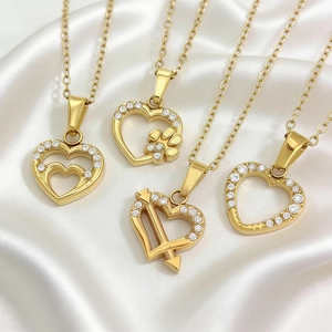 Set di quattro collane cuore in acciaio dorato con zirconi micro-pave su seta bianca