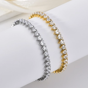 Dettaglio di bracciali tennis in oro e argento con zirconi a forma di cuore scintillanti