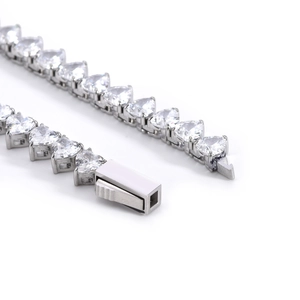 Macro di un bracciale tennis in argento con zirconi a cuore e chiusura a scatola