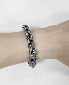 Close-up of vintage stainless steel skull link bracelet worn on a male wrist
