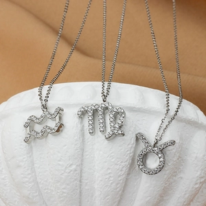 Détail macro de colliers signe du zodiaque argentés avec pendentifs constellation sertis