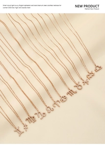 Détail de colliers signes du zodiaque en or rose sertis de cristaux sur satin