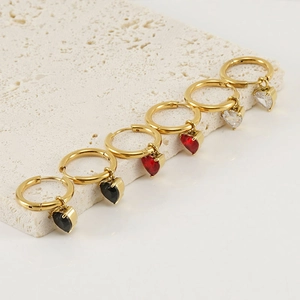Détail de boucles d'oreilles cœur en zircon or, rouge et noir sur support en pierre