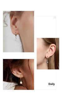 Close-up of teardrop zircon earrings in silver and gold finishes on a model
