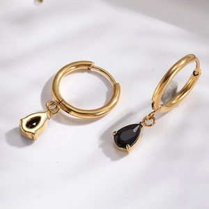 Macro detail of gold-plated teardrop earrings with black cubic zirconia stones