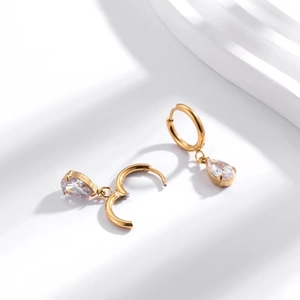 Macro shot of gold teardrop zircon earrings in high-quality stainless steel setting