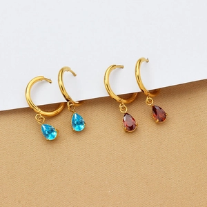 Detail of drop-shaped earrings with blue and red zircon crystals on gold hoops