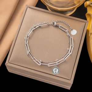 Vue détaillée du bracelet double couche en argent avec pendentif pièce et fermoir mousqueton