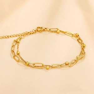 Détail d'un bracelet doré double épaisseur avec maillons trombone et petites perles